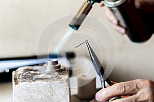 hands of a worker use gas burner in a workshop v