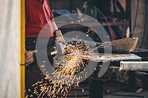 Hands of workers grinding steel in the metal industry