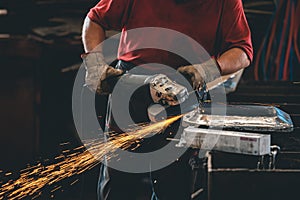 Hands of workers grinding steel in the metal industry