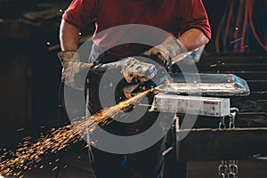 Hands of workers grinding steel in the metal industry