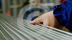 Hands working on the background of stainless steel pipes in factory.