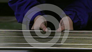 Hands working on the background of stainless steel pipes in factory.