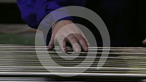 Hands working on the background of stainless steel pipes in factory.