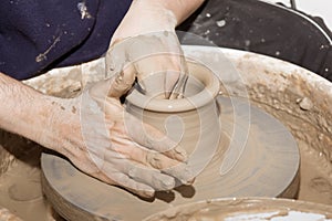 Hands working on a clay pot