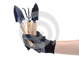 Hands in working gloves holding gardening tools rake shovel