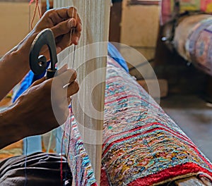 Hands working at one persian carpet, Srinagar, Jammu and Kashmir photo