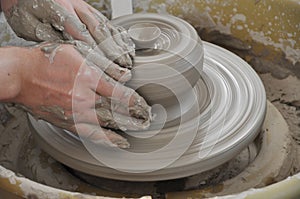 Hands working on pottery wheel