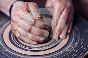 Hands working on pottery wheel