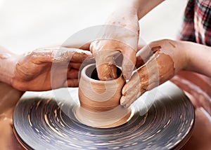 Hands working on pottery wheel