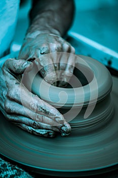 Hands working on pottery wheel , artistic toned