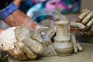 Hands working on pottery wheel , close up