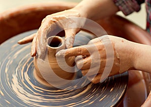 Hands working on pottery wheel