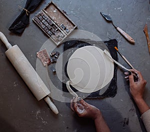 Hands working on pottery wheel , retro style toned