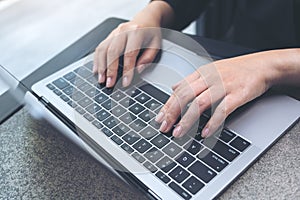 Hands working and typing on laptop keyboard in office