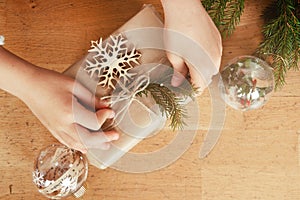 Hands wrapping present boubles christmas tree branches