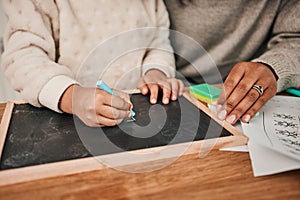 Hands, writing and mom with child on home, table for remote learning, education or drawing on chalkboard or desk in