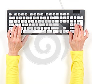 Hands in yellow jacket and grey keyboard