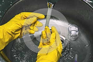 Hands in yellow protective gloves hold chemical flasks. Scientist experiment in the laboratory