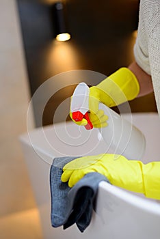 Hands with yellow rubber protective gloves cleaning bath