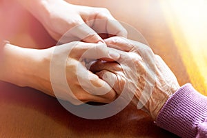 Hands of young adult and senior women. Care and elderly concept.