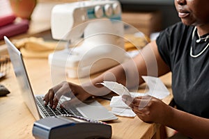 Hands of young African American woman with receit checking payment information