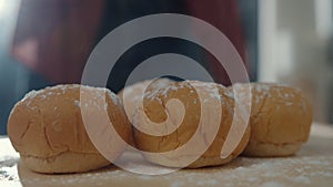 Hands of young Asian woman chef prepares dough with flour cooking whole grain bread on wooden board on kitchen table in house.