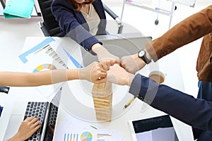 Hands of young business people giving fist bump together to greeting complete dealing in office. Success and teamwork concept.