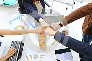 Hands of young business people giving fist bump together to greeting complete dealing in office. Success and teamwork concept