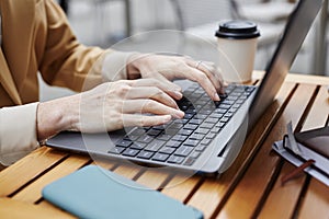 Hands of young businesswoman or solopreneur typing on laptop keyboard