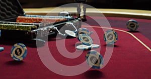 Hands of a young caucasian man playing poker in a casino. Close-up of hands playing poker with chips on red table.