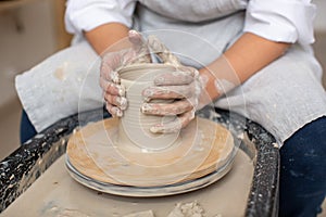 hands of a young ceramist on clay on a potter`s wheel