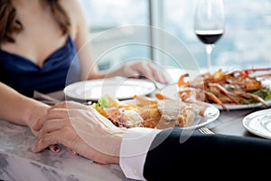 Hands of young couple date with romance together in anniversary at restaurant luxury for celebrate.