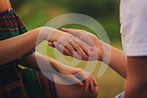 Hands of a young couple with a ring. close up of man giving diamond ring to woman