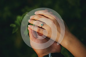 Hands of a young couple with a ring. close up of man giving diamond ring to woman