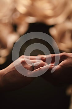 Hands of a young couple with a ring. close up of man giving diamond ring to woman