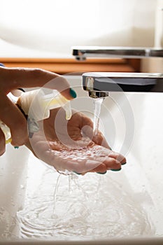 Hands of a young girl putting soap on herself