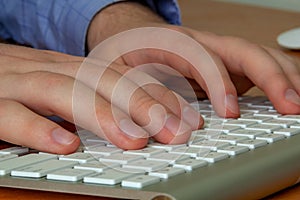 Hands of a young man on a computer keyboard close-up, with depth of field. The concept of learning. doing business and high
