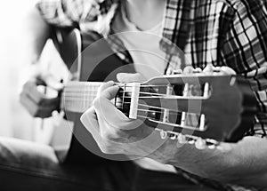 Hands of young man playing guitar. Black and white concept. Close-up