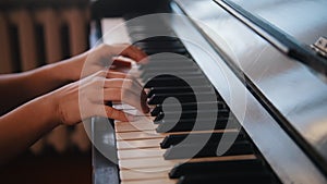 Hands of young teen girl playing on the piano