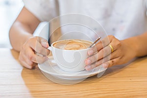 Hands of young woman with cocoa powder cup.