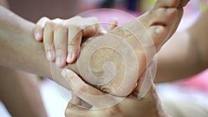 Hands of young woman gently touch massage to foot of old women metaphor and concept for body health care and therapy of family ol