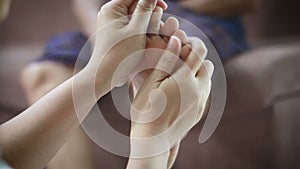 Hands of young woman gently touch massage to foot of old women metaphor and concept for body health care and therapy of family ol