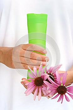 Hands of young woman holding cosmetics bottle