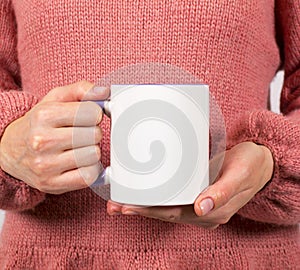 Hands of a young woman holding a Cup of coffee or tea.