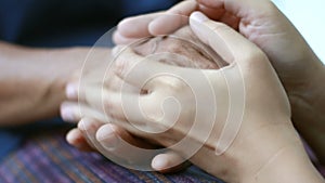 Hands of young woman holding and gentle touch to Hands of old women metaphor and concept for body language feeling love soothe and