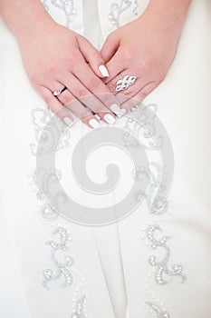 Hands of a young woman lying on her dress