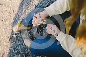 Hands of a young woman with the Mehndi inscriptions `Viva la Vida` and treble clef sign