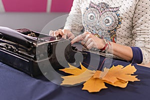 Hands of young woman, office worker, are typing text letter on old retro typewriter.