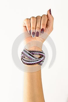 hands of a young woman showing painted nails, white background.