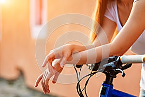 The hands of young woman sitting on bicycle